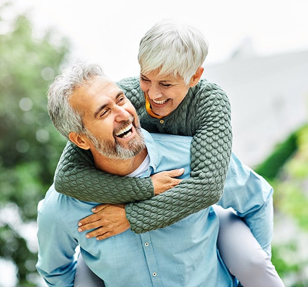 woman man outdoor senior couple happy lifestyle retirement together smiling love piggyback active mature