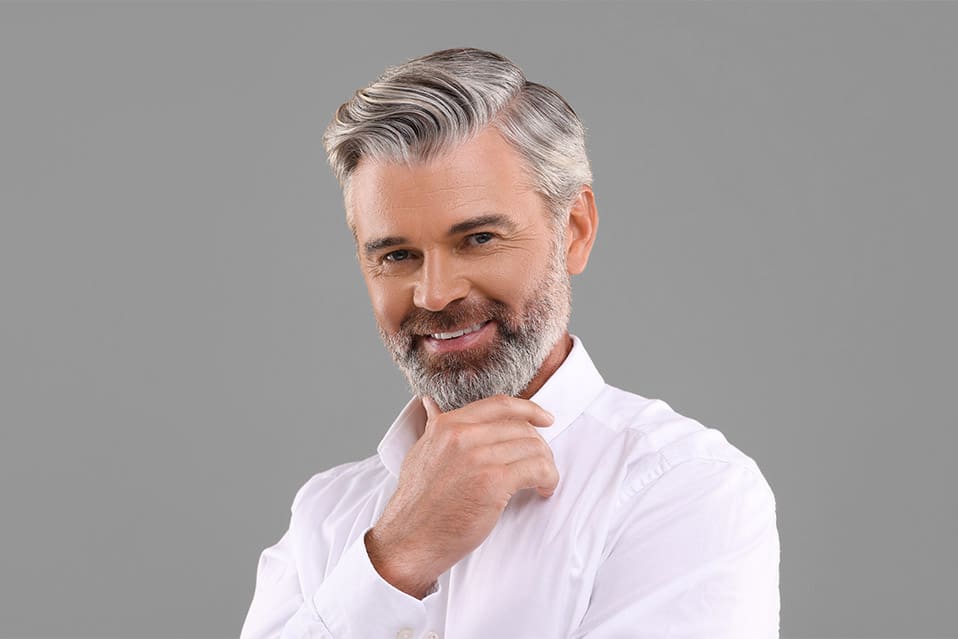 Portrait of smiling man with beautiful hairstyle on light brown background